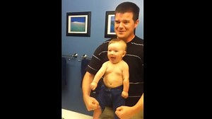 Adorable baby flexes his muscles alongside dad