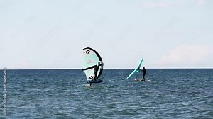 Modern water sport. Hydrofoil ride on the ocean using the wing and the power of the wind. the best place for kitesurfers, video of fit athlete practise hydro foil wing surfing