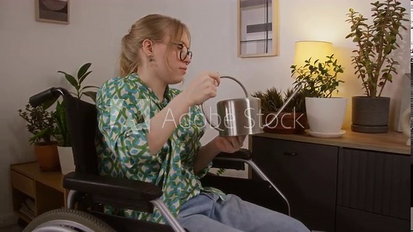 Gen Z girl with paraparesis watering plants from tin watering can while doing housework in cozy room