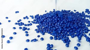 Blue masterbatch granules falling like rain water from above filling the aluminum cup container, isolated on white background, for plastic industry product profile video