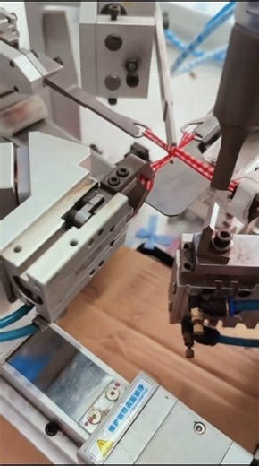 sebuah mesin pembuat pita otomatis (Automatic Ribbon Bow Tying Machine) yang sedang bekerja
