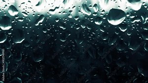 Texture Raindrops close-up, drops flow down on the glass against a background in the dark