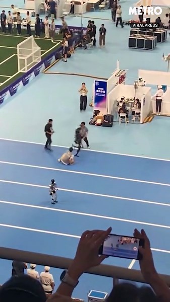 Robot athlete pushes human man to the floor at Humanoid Games
