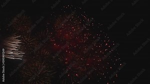 4K-Slow-motion - the vertical shot of shining of a real fireworks explosion on the dark sky background, fireworks festival Show, celebrate fireworks, Christmas and happy new year celebration.