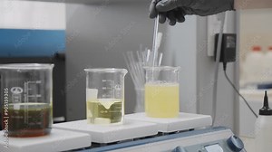Scientist weighing samples on a digital scale in a laboratory with microscope and chemicals in background
