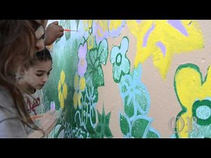 Children from SmartKids Learning Center paint mural