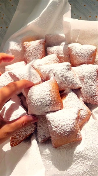 Beignets at home ☕️🍴 ________________________________ Ingredients: (makes 35-40 beignets) . ¾ cup lukewarm water . 1 .25-ounce packet active dry yeast . ½ cup evaporated milk . ⅓ cup sugar . 1/4 tsp salt . 1 egg . 1 tsp vanilla extract . 4 cups all-purpose flour . 3 tbsp melted butter . Neutral oil (for frying) . powdered sugar (for dusting) ________________________________ Directions: . In a large bowl, combine the water and yeast. . Let the mixture rest for 5-10 minutes ( should look frothy).