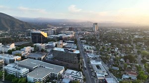 Aerial stock drone footage of Burbank, California flying towards Warner Bros and Universal Studios at sunset