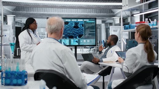 Laboratory manager presenting innovative drug development findings to biologists. African american female scientist pointing at screen displaying DNA genomes during training meeting, camera B