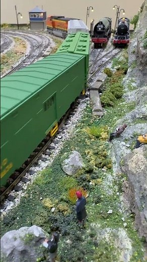 Dash 8-40CW in BNSF livery pulling box cars past the embankment.