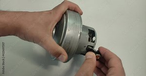 Service center foreman repairs the electric motor of the vacuum cleaner