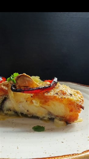 Bacalhau no Forno com Esmagada de Batata Simples. Daqueles pratos que enchem a casa de aroma e pedem pão na mesa. Ingredientes: 4 postas de bacalhau demolhado (lombo) 1 cebola grande laminada Farinha q.b. 4 a 5 dentes de alho esmagados 2 folhas de louro Pimenta preta q.b. 2 a 3 nozes de manteiga Um bom fio de azeite Tiras de pimento vermelho e verde Batatas pequenas com pele Forro o tabuleiro com cebola laminada. As postas de bacalhau passam por farinha — porque o sabor começa aqui. Alhos esmaga