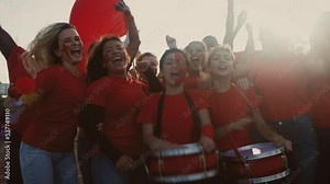 Crowd football fans cheering while watching soccer game at stadium - Sport entertainment concept