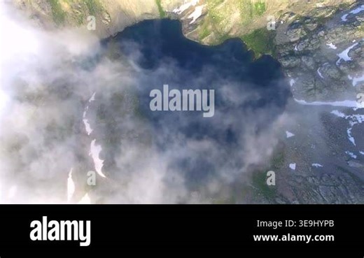 Aerial view of an alpine lake amid tundra meadows in the Rocky Mountains at high altitude. Clear summer light reveals rugged peaks, pristine wilderness, and remote American ranges Stock Video Footage - Alamy