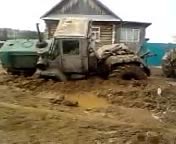 Struggling Blue Tractor in Muddy Rural Terrain