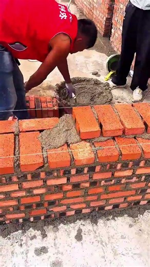 building walls with bricks and cement mixing mortar working hard on site constructing