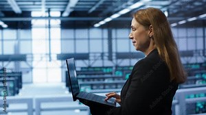 Computer scientist doing yearly maintenance using laptop to prolong data center equipment life span. IT specialist in server hub facility monitoring server infrastructure using device, camera A