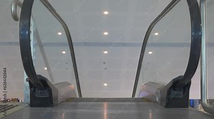 Close up, the top of a moving escalator at the airport.