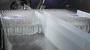 High-definition footage of an automated cleanroom assembly where glass ampoules are washed, filled with injectable medication, sterilized, and hermetically sealed. Showcases precision robotics, strict