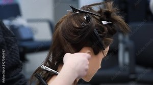 beginner hairdresser practices new skills on a dummy head, combs and make hair parting, training at hairdressing workshop, learning new profession or refresher course