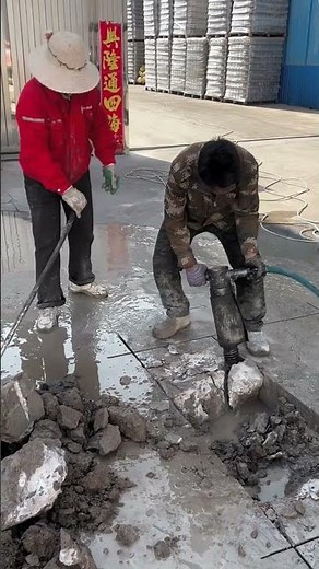 Using a power chisel to remove solidified concrete from the factory floor