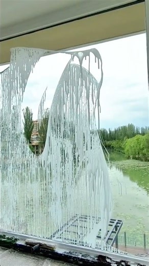 Removing protective film from large glass window to reveal clear surface during finishing work now