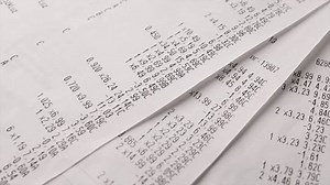 Supermarket shopping bill and receipt from the cash register. Close-up of paper grocery shopping receipts.