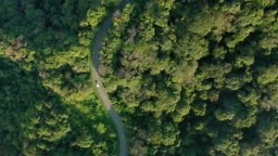 4k Real time aerial view with tracking shot of car driving passing a...