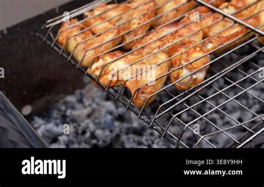 BBQ picnic time Roasted chicken legs and wings on grill. Grilling meat on outdoor grill grid tasty barbeque chicken steak with smoke flames juicy meat in the backyard in summer