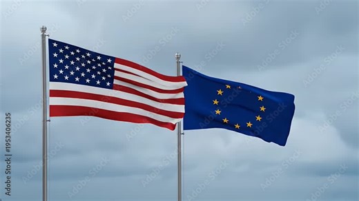 Flags of the USA and European Union - The American and European Union flags are displayed waving together in front of a cloudy sky. The flags are brightly colored and stand out against the gray sky.