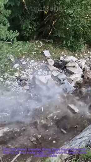 Mountain Slope Hazard Removal: Worker Breaking Loose Rocks to Prevent Falls