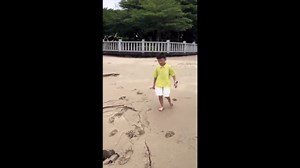 Boy falls into sand hole on beach
