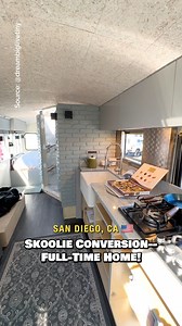 Would you live in this skoolie conversion into a full-time home on the road? Inside, there is a living area with a built-in couch, a dining table for 3, a kitchen with apartment-size appliances, a large wet bath with a shower & toilet (still unfinished in video), & a bedroom with some storage in the back! I saw this bus at the San Diego TinyFest! #skoolie #schoolbus #skoolieconversion #vanlife #camper | Dream Big Live Tiny Co.