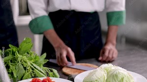 hand chef in cooking school kitchen show chopping or slice vegetable skill to young students, chef trainee with uniform prepare ingredients of healthy nutrition or Asian food for cuisine in kitchen