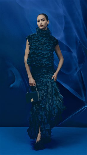 There is an interesting, ultralight 3-dimensionality that comes alive through movement. The taffeta ribbon fabric is an exclusive Akris studio development. Laser-cut ribbons are sewn into triangular shapes and arranged onto the base fabric in parallel lines, varying in size from top to bottom. This workmanship creates a dynamic texture, giving the fabric its effortless, airy charm — perfect for modern eveningwear. #Akris #AkrisFall25 | Akris