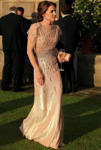 The image of Kate Middleton in a stunning light pink dress is gorgeous! 💃 The silver sequins and sheer overlay give her look a touch of glamour, perfect for a fancy outdoor event 🌳. Her elegant updo and champagne glass add to the sophisticated vibe 💫. #PrincessCatherine #KateMiddleton #RoyalFashion #DuchessOfCambridge #RoyalStyle | Royal legacy