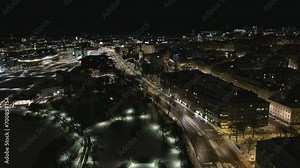 Helsinki.Finland-January 18.2022: Drone shot of a tram driving in the downtown of Helsinki Finland. Cityscape. Nighttime. Wintertime. Tramway. Public transportation. Camera slowly moving backwards.