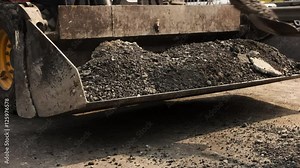 Shovels throwing asphalt. Bucket of wheel loader. Use more durable materials. Building roads demands effort.