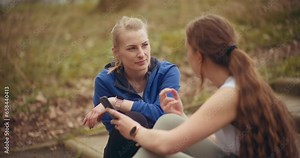 Woman talking with friend sharing mobile phone