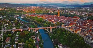 Aerial view establishing shot of the famous old distric in Berne, with historic bridge spanning across the Aare river. Bern town, the capital city of Switzerland with colorful twilight romantic sky
