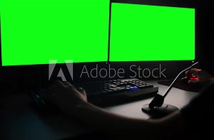 working with two monitors in dark, green screen
