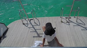 Attractive woman enjoying on the sailing yacht with tourquoise sea, luxury vacation concept