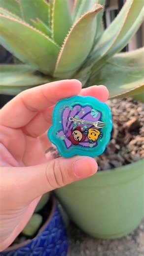 Inspired Phone Grips, Badge Reels & Keychains on Instagram: "Handmade treasures from under the sea! Little mermaid theme charms are now available! Choose from flounder, Sebastian, Ursula or Ariel herself! All charms are available as a swappable phone grip, magnetic phone grip, badge reel or keychain! 🌊🐚 #princess #mermaid #phonecharm #badgereel #bagcharm #shakercharm #shopsmall #resinart"