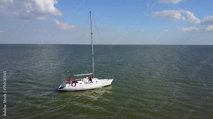 2017-08-08 - Mariupol, Ukraine. Lastochka Yacht. Sailboat cruises calm sea, crew visible on deck. Historical vessel, pre-war imagery, serene maritime travel near coast.