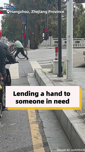 When a man with difficulty walking struggled to pull a tricycle of goods uphill at an intersection, a passing e-motorcycle rider made a U-turn to lend a helping hand. #HeartofChina | China Q&A