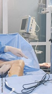 A team of surgeons during an operation to remove veins - phlebectomy. Surgical operation in the clinic. Vertical video