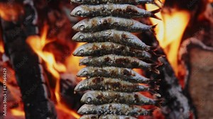 Sardines on skewers are cooked on fire. Andalusia, Malaga