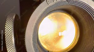 The flickering lights of an old movie projector as a background- An Intricate CloseUp View of a Vintage film projector Lens