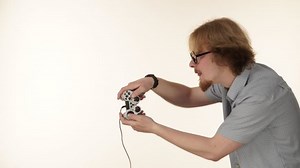 Videogame addicted guy playing with controller console. Young male gamer with pad joystick playing games, side view 4K ProRes HQ codec