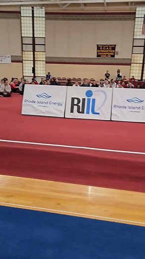 RI Energy President Greg Cornett & RIIL Assistant Executive Director Tom Marcello present medals to the top six all-around finishers and the Jackie Court Award to 2025 RIIL All-Around State Champion Gianna Desmarais of Cranston West. | Rhode Island Interscholastic League